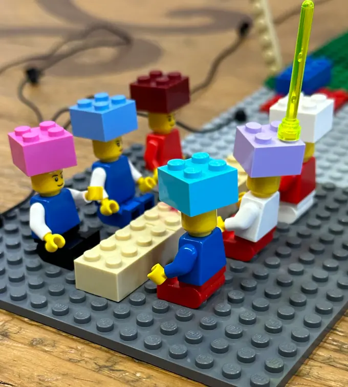 Personaggi LEGO seduti attorno a un tavolo durante un laboratorio