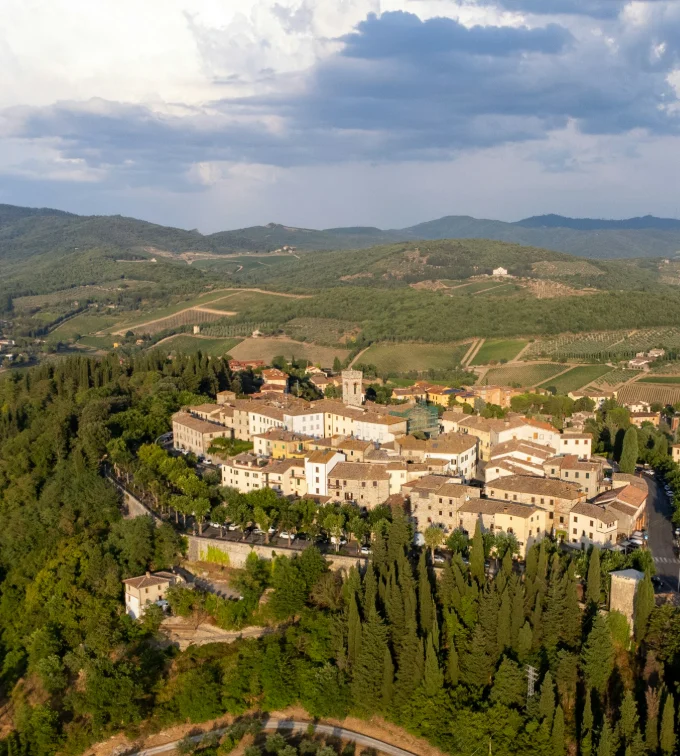 Un paese di collina tra boschi e vigneti, visto dall'alto